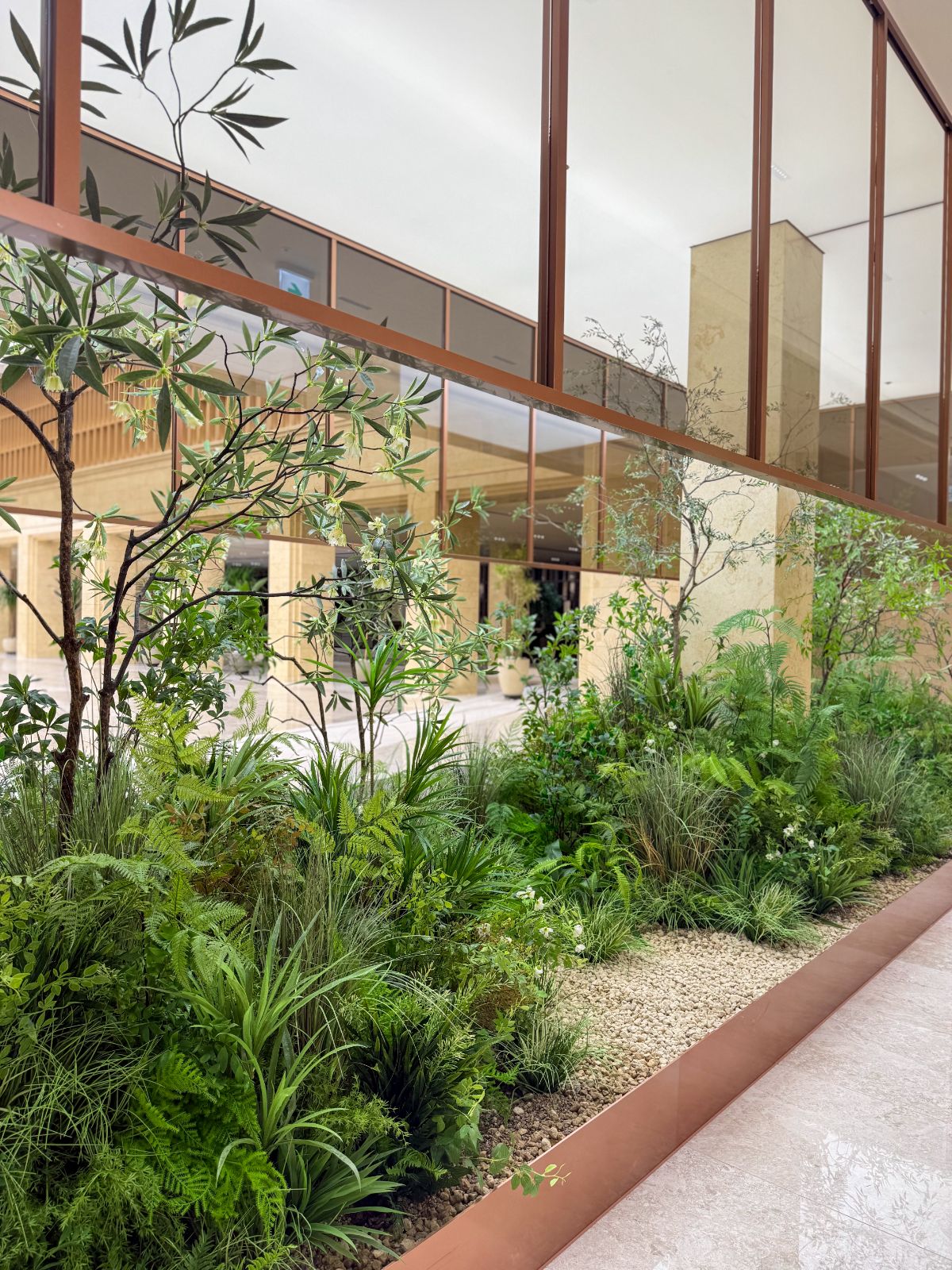 Radomus interior landscaping with ferns and grasses along a lobby planter