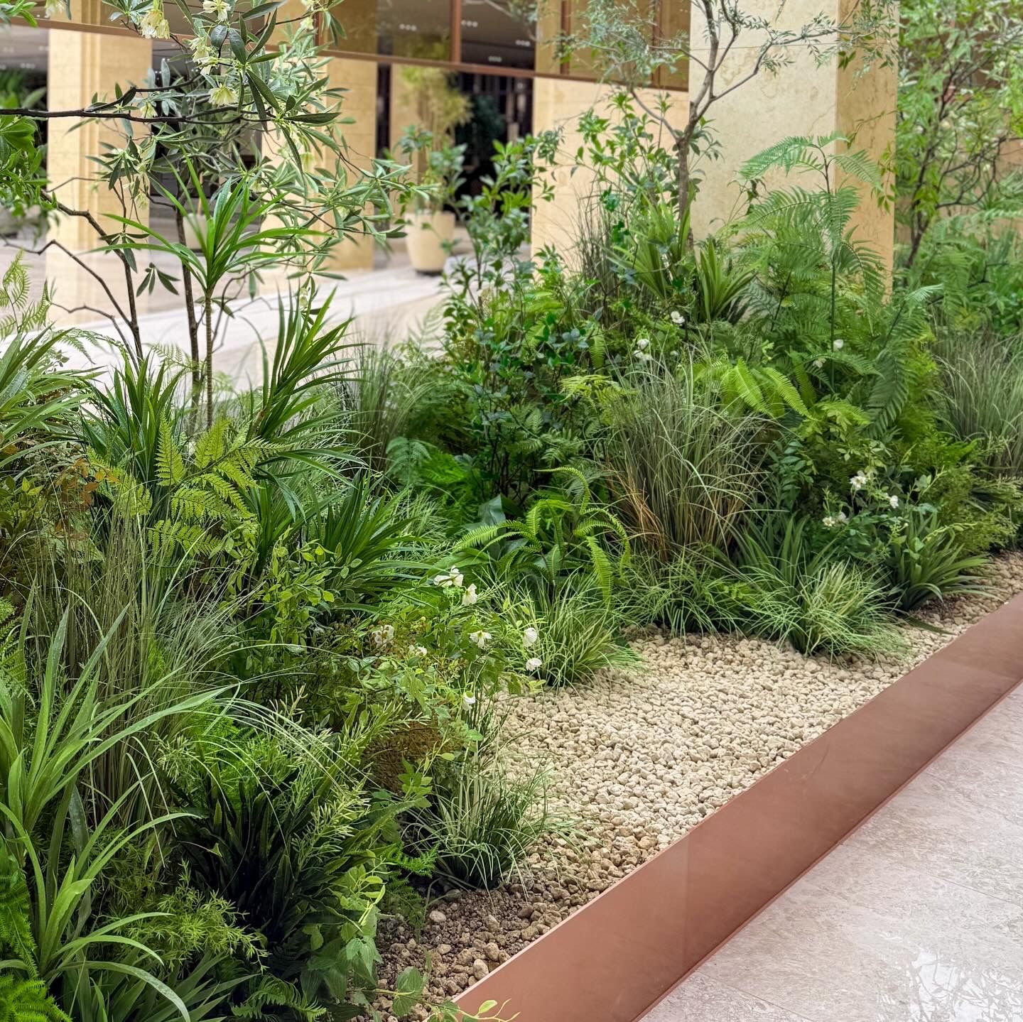 Radomus interior landscaping with ferns and grasses along a lobby planter