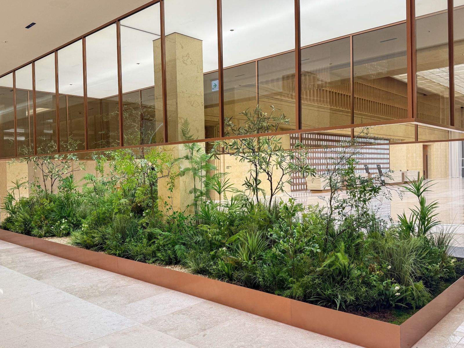 Radomus interior landscaping with ferns and grasses along a lobby planter